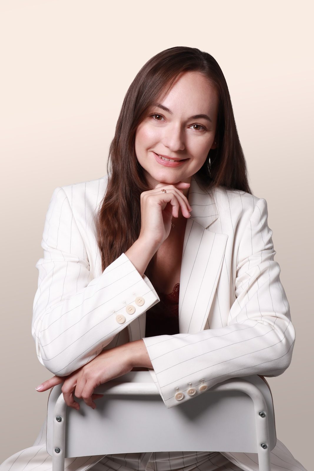 Aurelia Wala w jasnej marynarce, uśmiechnięta